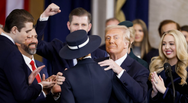 President Donald Trump embraces his wife, Melania Trump, after taking the presidential oath on Inauguration Day with his children congratulating him by his side. 
(US Embassy)